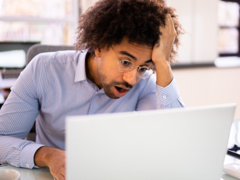 A man looking frustrated while working on his laptop