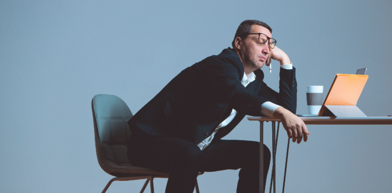 A man slumped over his desk