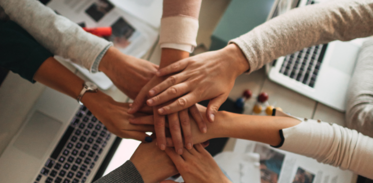 People putting their hands together in a circle