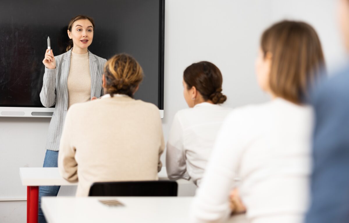 A woman training a classroom of working professionals