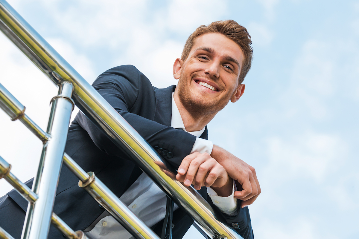 A business man leaning over a railing