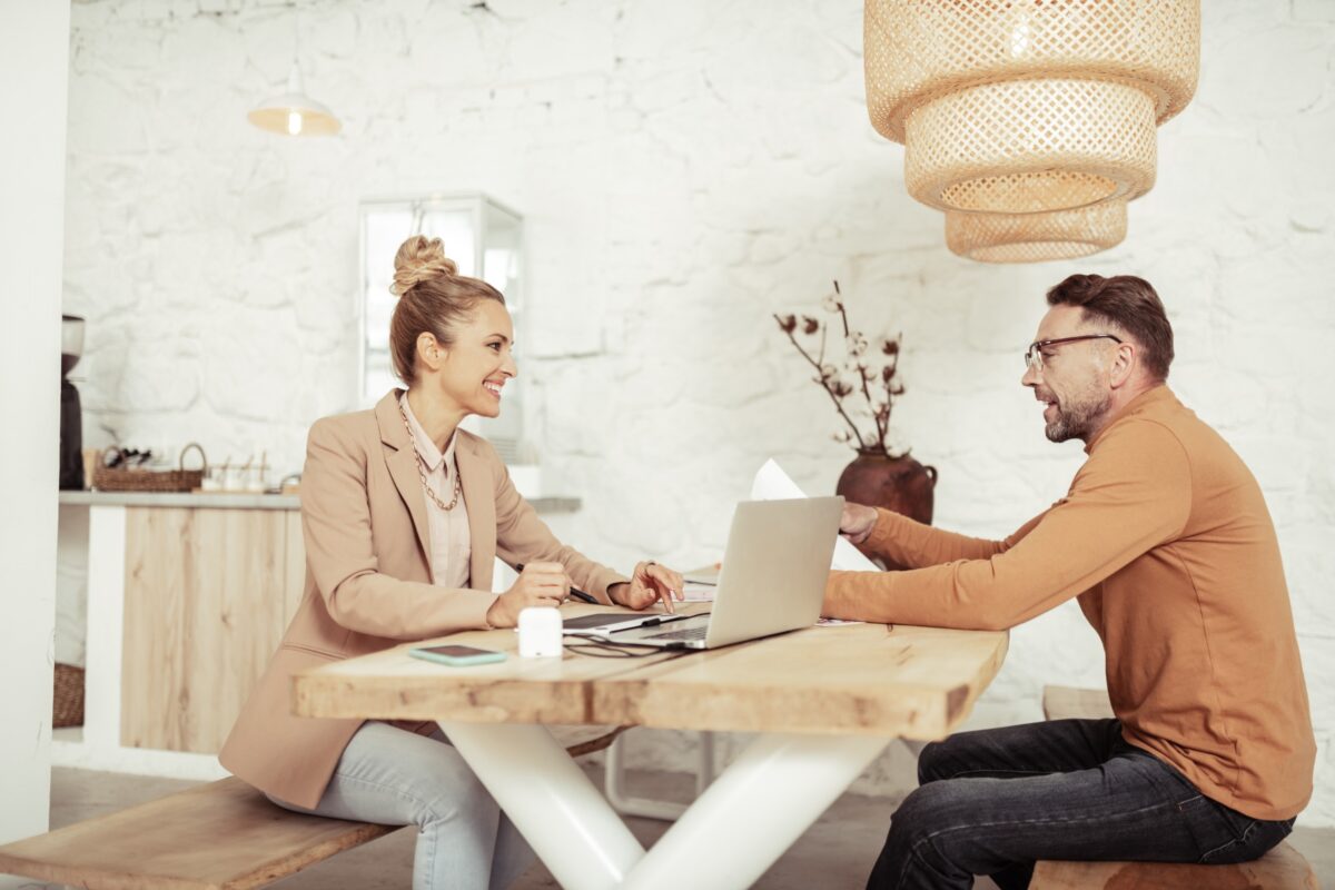 A woman and a man in an office sitting across from each other while talking