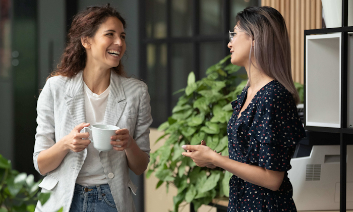 Two women talking to each other in an office break room