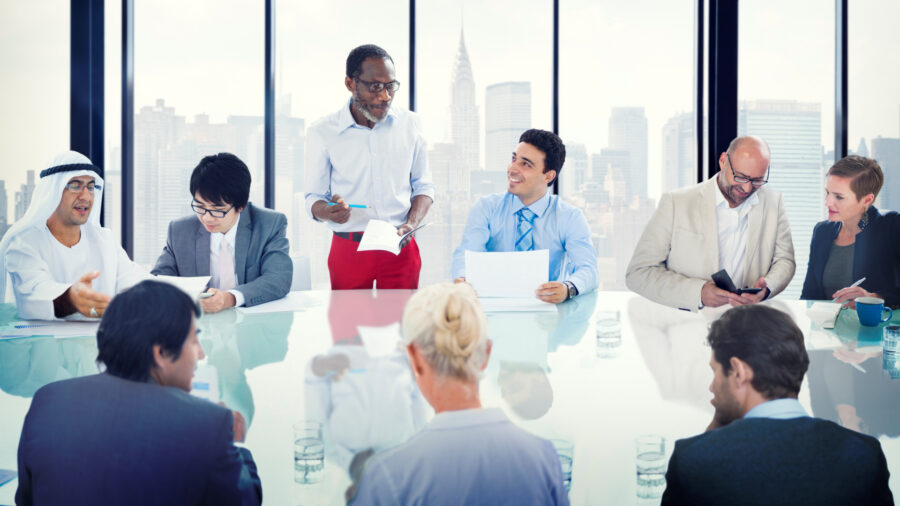 A diverse group of men and women talking around a conference table