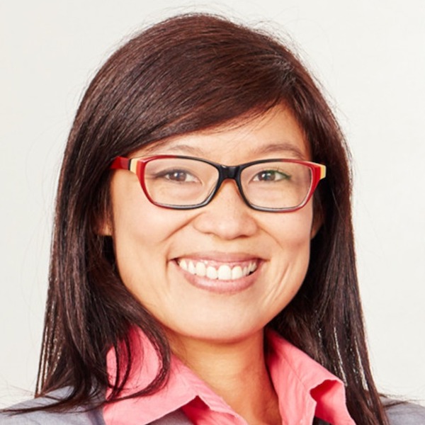 Headshot of an Asian woman wearing red glasses