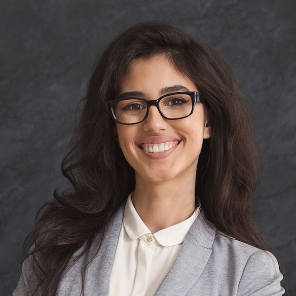 Headshot of a professional business woman wearing glasses and a suit