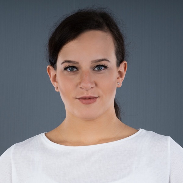 Professional headshot of a woman with brown hair pulled back