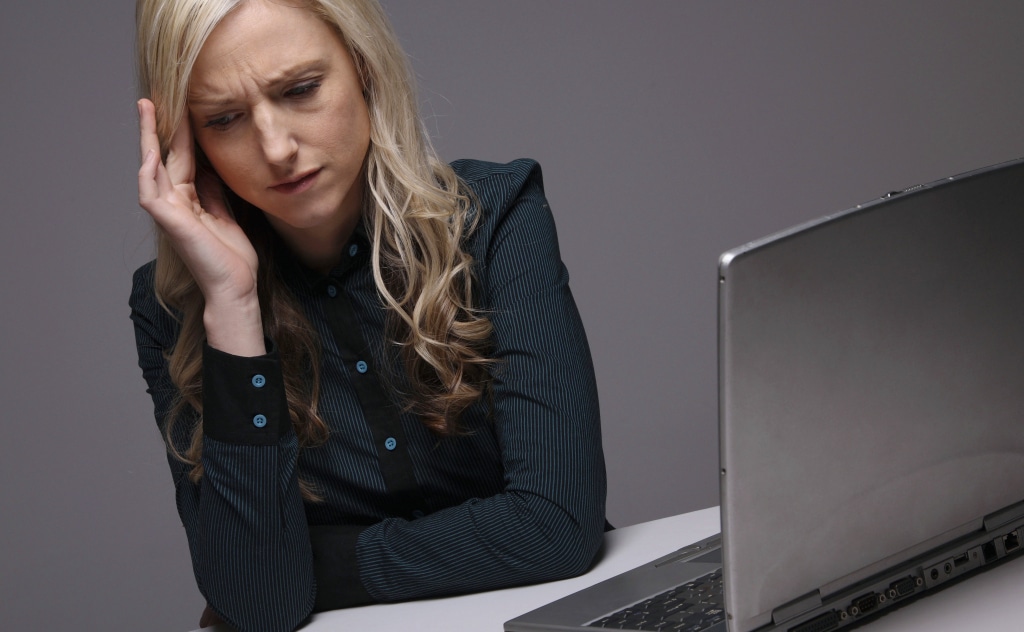 A woman stressed while working at her computer