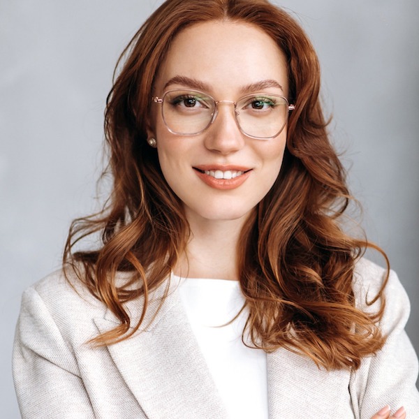 Headshot of a woman with red hair and glasses
