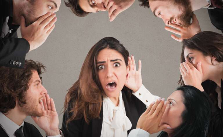 People in a circle whispering in each other's ears