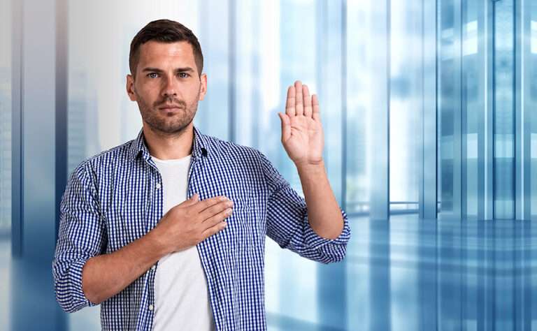 A man holding his left hand up with his right hand over his heart