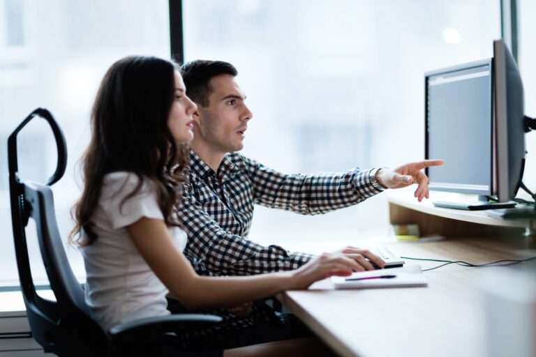 A man and a woman working on a computer together