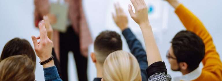 People raining their hands in a classroom training event