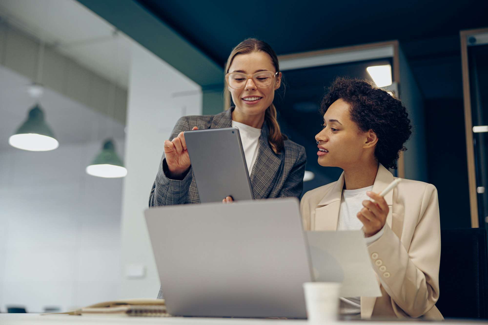 Smiling business woman work together with documents at the office wand use digital tablet and