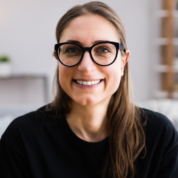 Headshot of a smiling woman with glasses