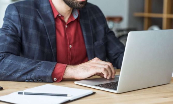 A man using his computer at work to help with his business