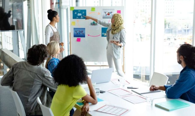 A woman presenting her plan to a few coworkers