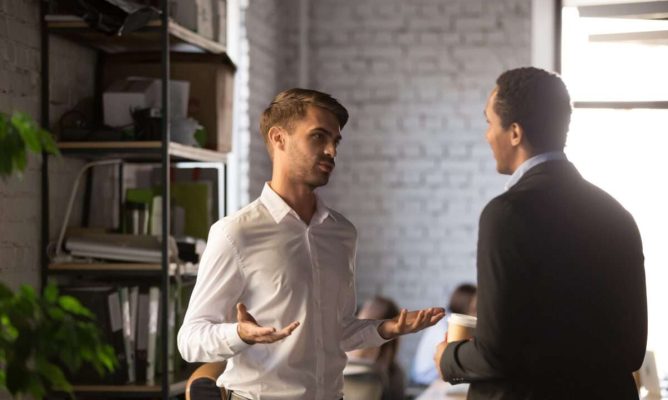 Two men in the office talking to each other
