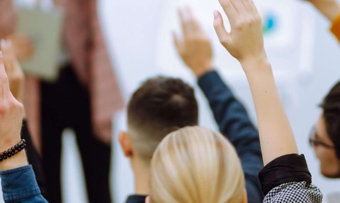 People raining their hands in a classroom training event