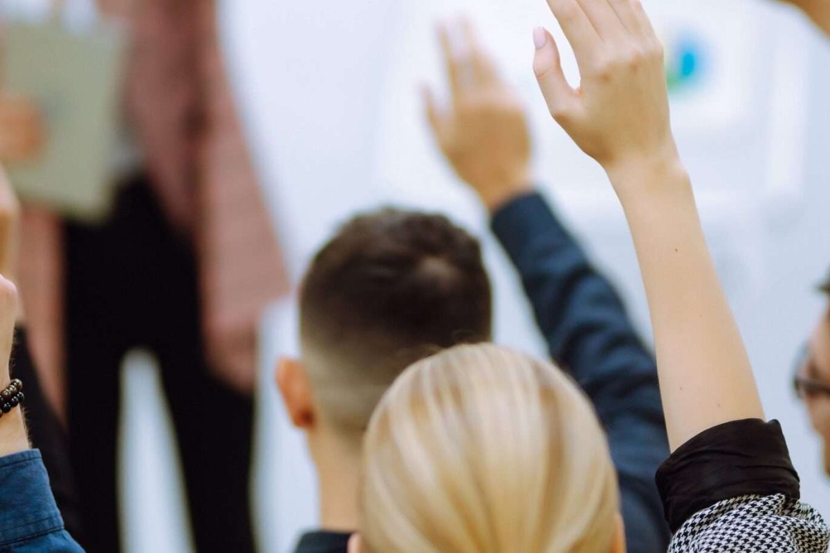 People raining their hands in a classroom training event