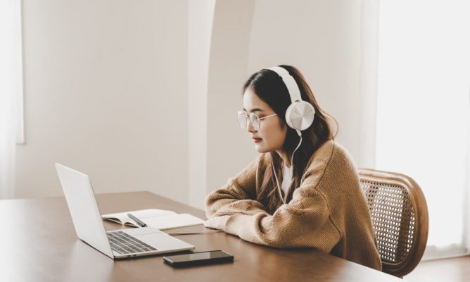 Girl wearing headphones looking at a computer