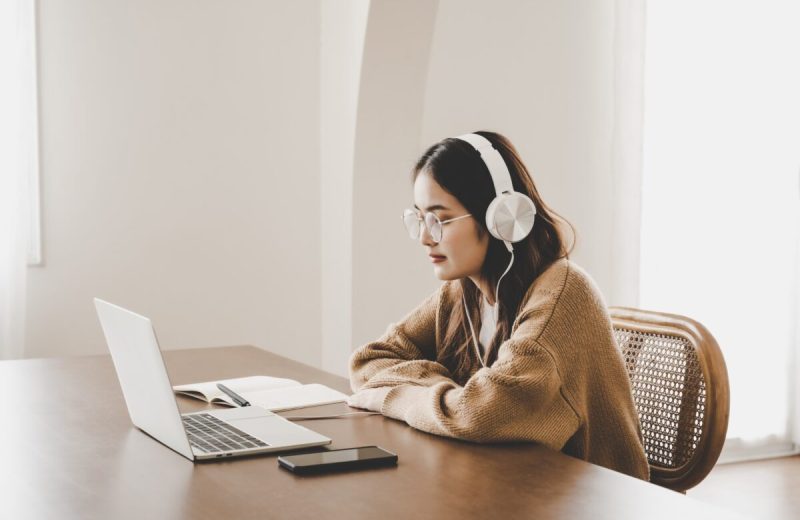 Girl wearing headphones looking at a computer