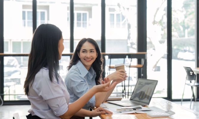 Two female coworkers creating a supportive work environment