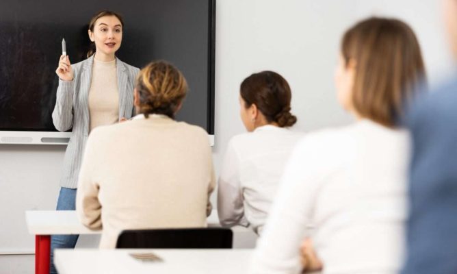 A woman training a classroom of working professionals