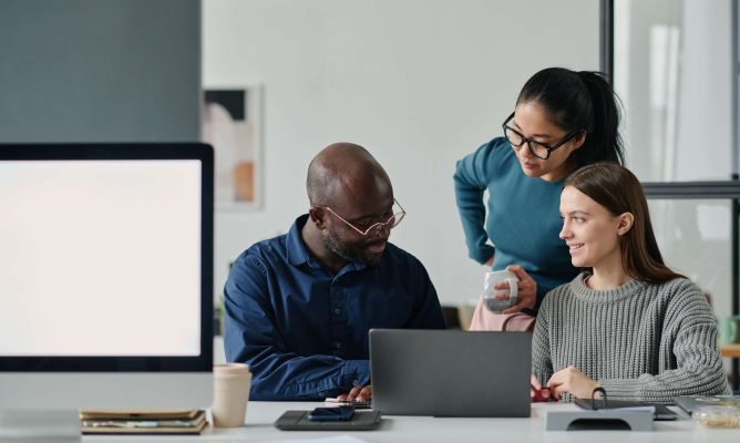 A diverse group of three coworkers working together