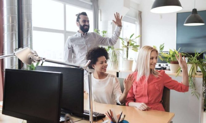 Three coworkers waving