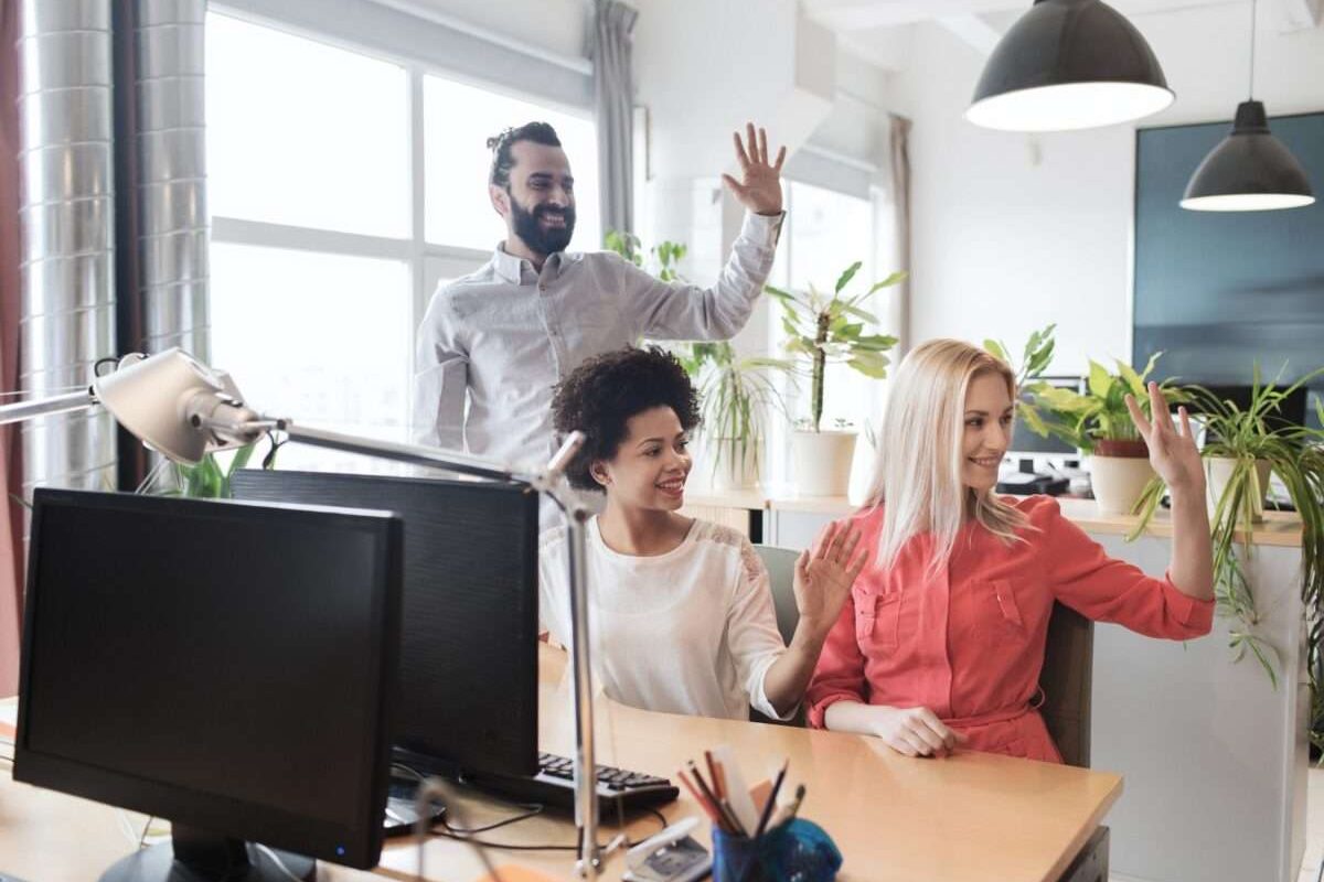 Three coworkers waving