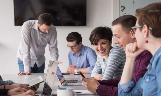 A team meeting with three male and two female coworkers