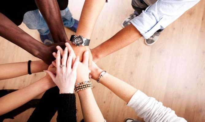 People putting their hands together in a circle