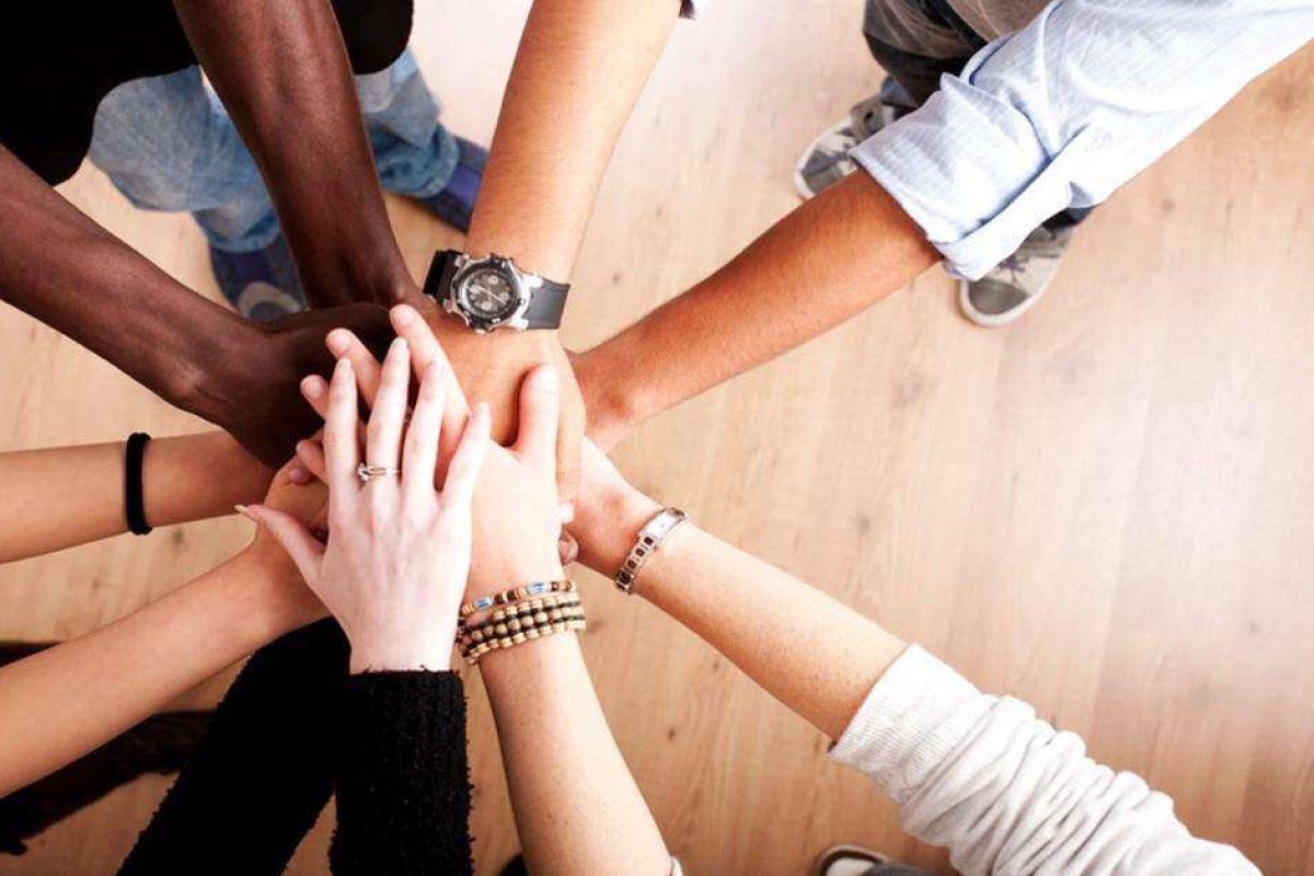 People putting their hands together in a circle