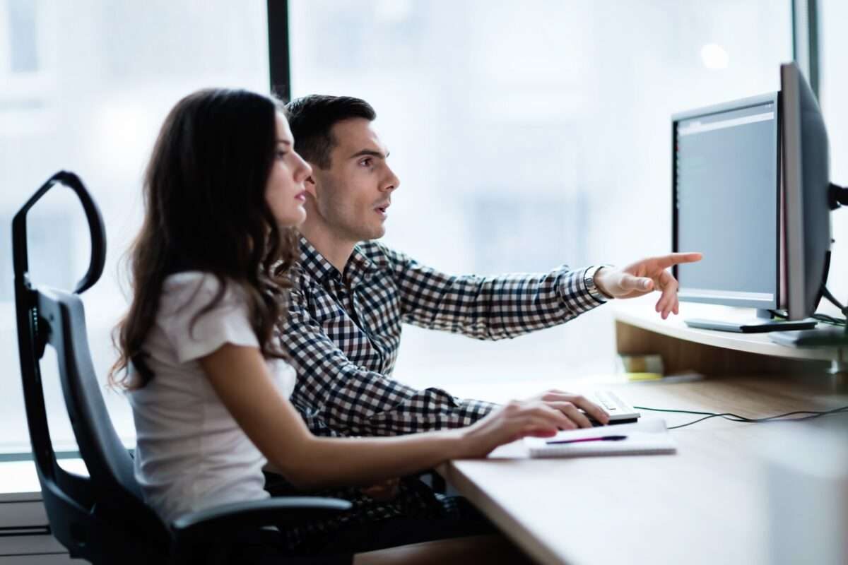 A man and a woman working on a computer together
