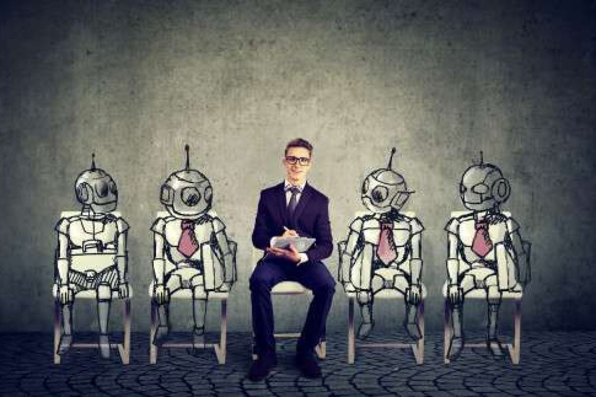 A man in a suit sitting in between four robots