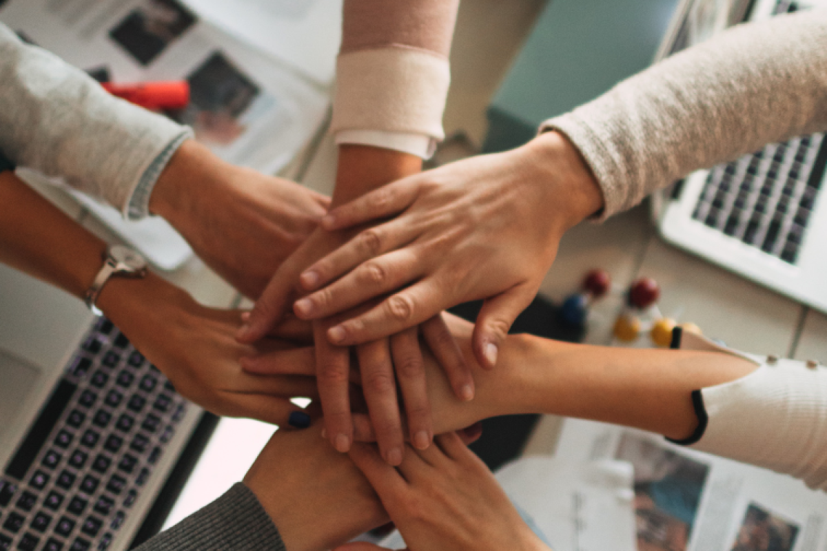 People putting their hands together in a circle