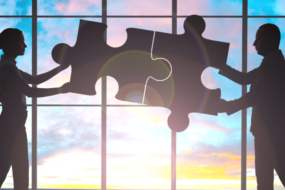 Outlines of a man and a woman sticking puzzle pieces together