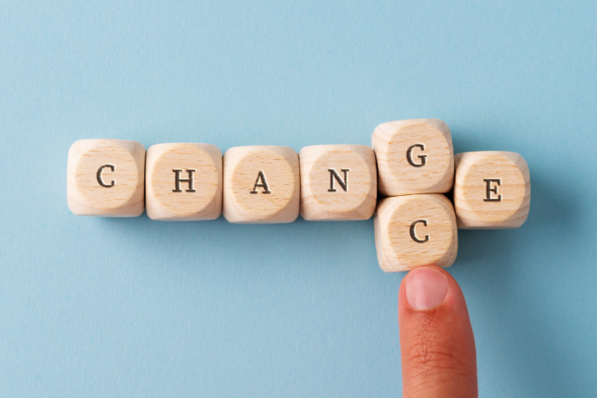 Blocks that spell out "change" with a finger pushing the G block out and replacing it with a C block to spell "chance."