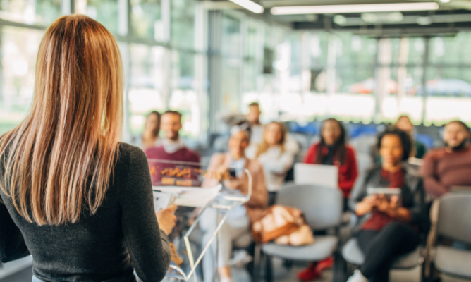 A woman speaking in front of a small audience