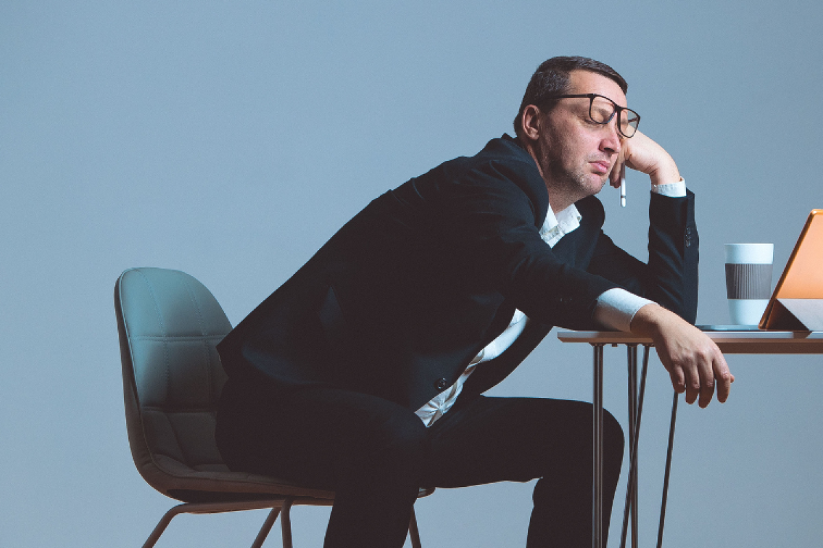 A man slumped over his desk