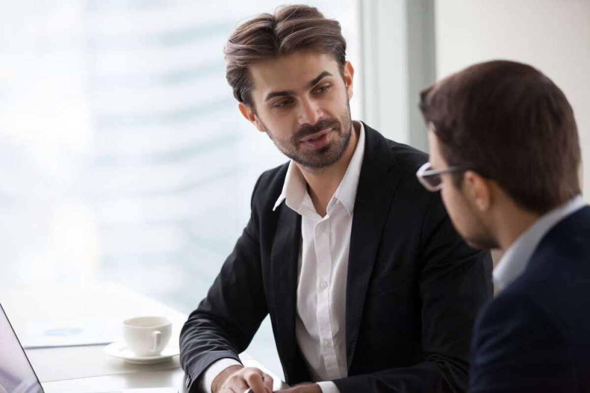 Two male coworkers talking and listening to each other