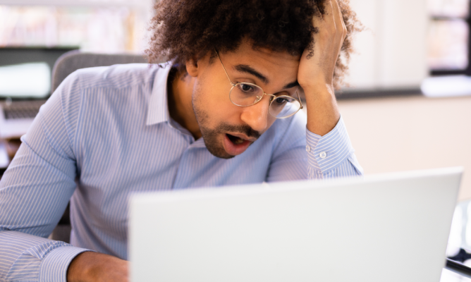 A man looking frustrated while working on his laptop