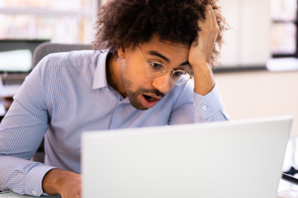 A man looking frustrated while working on his laptop