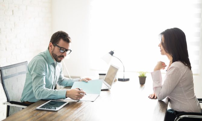 A woman asking for a raise at work