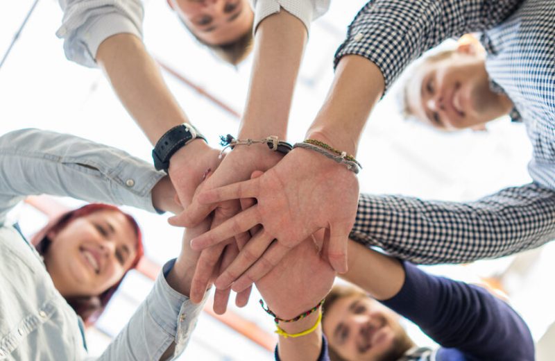A group of coworkers putting their hands together in a circle