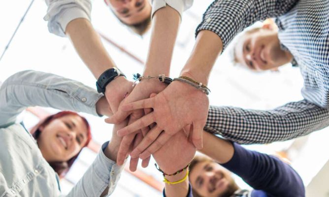 A group of coworkers putting their hands together in a circle