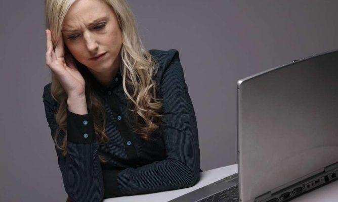 A woman stressed while working at her computer