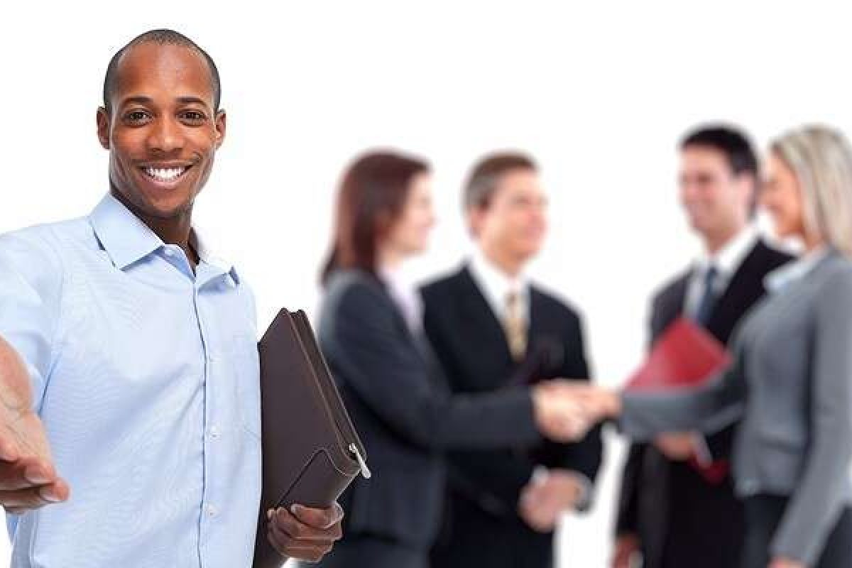 A small group of coworkers talking in the background with a man in the front with his hand extended outward