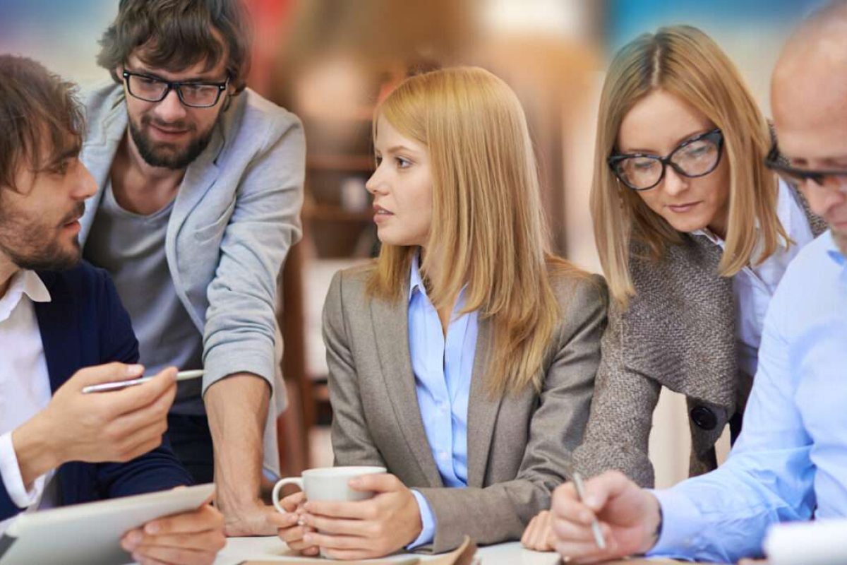 Three male and two female coworkers working on a project together